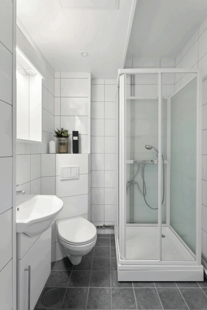 White tiled bathroom with clean lines, minimal decor, and subtle elegance